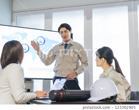 A group of workers meeting in front of a large screen monitor 123302905