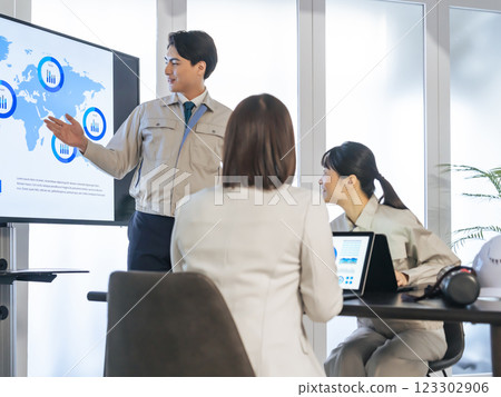 A group of workers meeting in front of a large screen monitor A group of workers meeting in front of a large screen monitor 123302906