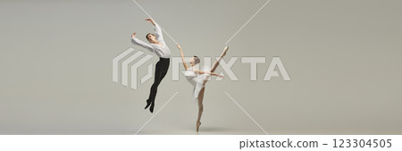 Banner. Ballet dancer spinning in controlled turn, partner gazing with admiration, delicate lines enhancing moment against white studio background. 123304505