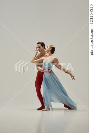 Ballet pair in graceful pose, ballerina leaning back, partner supporting with effortless elegance against white studio background. 123304539