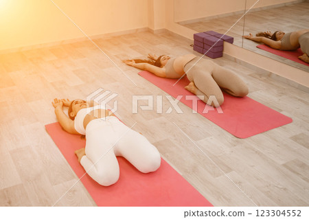 Two beautiful women do yoga, sports in the gym. The concept of grace and beauty of the body. 123304552