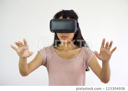 Asian teen using virtual reality glasses, play an interactive game. Future Technology Concept. 123304936