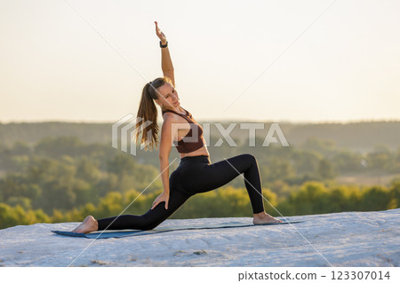 Young woman stretching her body at sunset on a scenic overlook 123307014