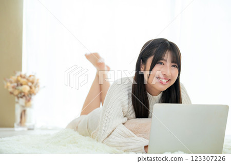 一名女子趴在地上使用電腦 123307226