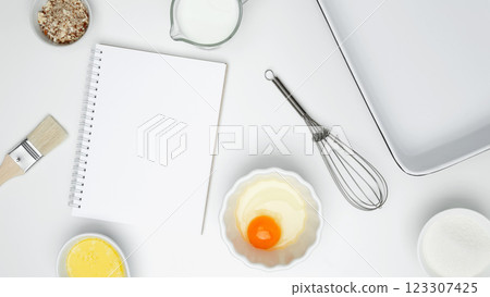 Baking ingredients for Crinkle Cake, including butter, milk, sugar, egg, nuts, open white notebook 123307425