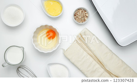 Baking Crinkle Cake, near dish with ingredients, phyllo dough, egg, butter, nuts, milk Baking Crinkle Cake, near dish with ingredients, phyllo dough, egg, butter, nuts, milk 123307428