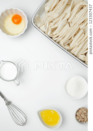 Crinkle Cake baking filo dough in a baking dish near milk, eggs, butter, butter, sugar 123307437