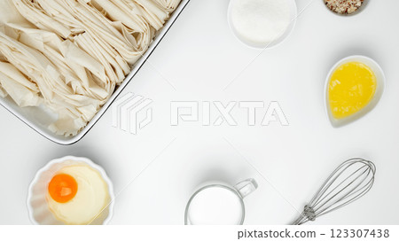 Crinkle Cake baking filo dough in a baking dish near milk, eggs, butter, butter, sugar 123307438