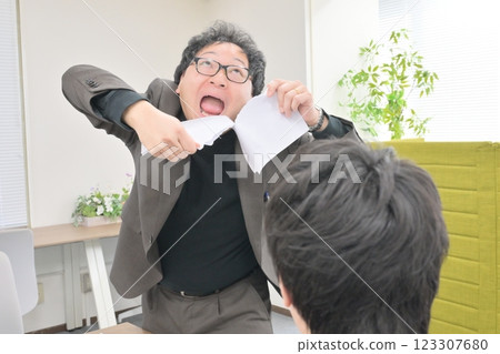 A man making a fuss and tearing up documents A man making a fuss and tearing up documents 123307680