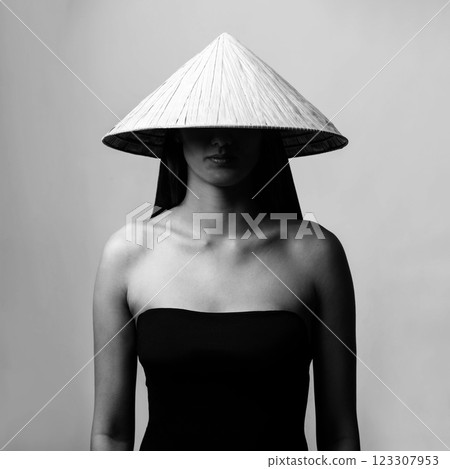 Beautiful woman with Asian cane hat black and white studio portrait 123307953