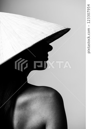 Beautiful woman with Asian cane hat black and white studio portrait 123307954