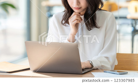 A woman/businesswoman thinking while looking at a computer screen A woman/businesswoman thinking while looking at a computer screen 123307985
