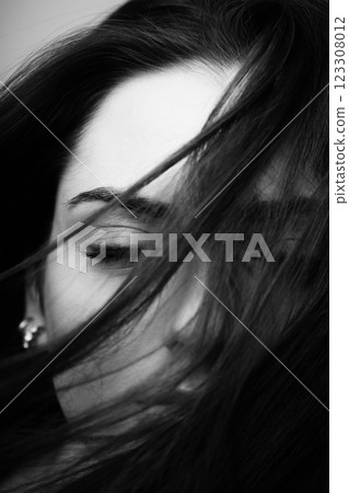 Woman portrait with part face covered with hairs by blowing wind Woman portrait with part face covered with hairs by blowing wind 123308012