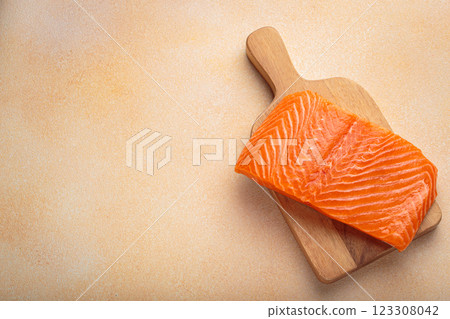 Fresh salmon fillet on cutting board, delicious and healthy meal preparation top view, space for text Fresh salmon fillet on cutting board, delicious and healthy meal preparation top view, space for text 123308042