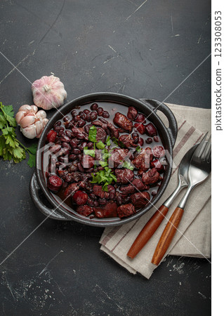 Brazilian feijoada with black beans, sausage and meat in a pot, top view Brazilian feijoada with black beans, sausage and meat in a pot, top view 123308053
