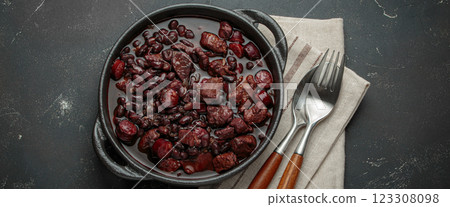 Brazilian feijoada with black beans, sausage and meat in a pot, top view 123308098