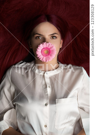 Woman with red hair and flower in her mouth 123308129