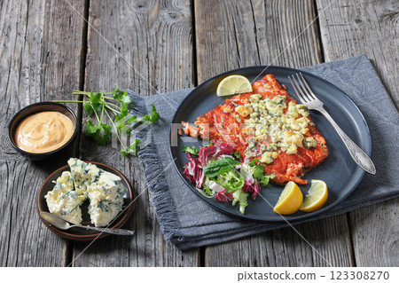 baked salmon topped with blue cheese on a plate 123308270