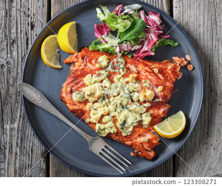 baked salmon topped with blue cheese on a plate baked salmon topped with blue cheese on a plate 123308271