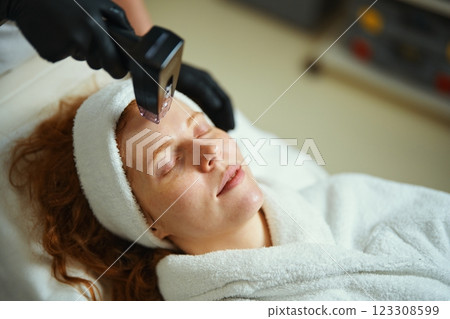 Woman receiving facial treatment in a spa during a wellness session 123308599
