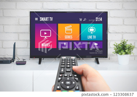 Man watching TV, remote control in hand 123308637