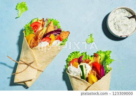 Greek chicken gyro wraps on blue background Greek chicken gyro wraps on blue background 123309000