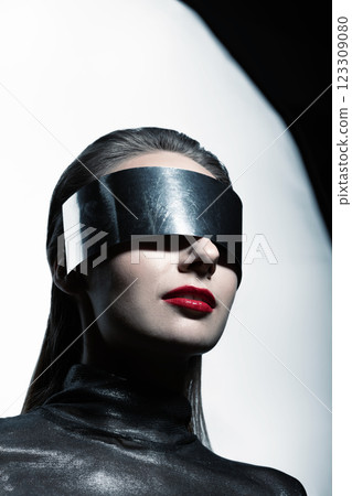 Abstract woman studio portrait with make-up and metallic eyeglasses or helmet covering her eyes 123309080