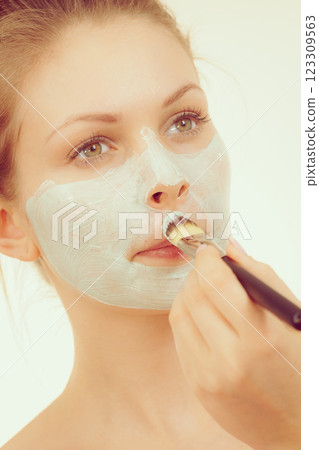 Girl apply green mud mask to face Girl apply green mud mask to face 123309563