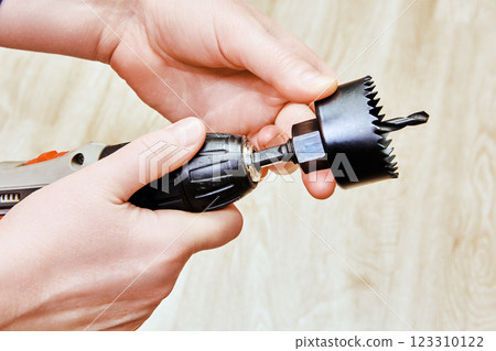 Cordless screwdriver and hole saw, equipped with drill bit, facilitate clean and accurate hole creation for door locks. Cordless screwdriver and hole saw, equipped with drill bit, facilitate clean and accurate hole creation for door locks. 123310122