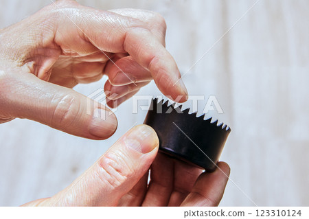 Interior view of hole saw showing attachment and pilot holes. Interior view of hole saw showing attachment and pilot holes. 123310124