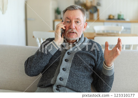 Happy middle aged senior man talking on smartphone with family friends. Older mature grandfather with cell phone talking with grown up children, resting at home. Older generation modern tech usage Happy middle aged senior man talking on smartphone with family friends. Older mature grandfather with cell phone talking with grown up children, resting at home. Older generation modern tech usage 123310177