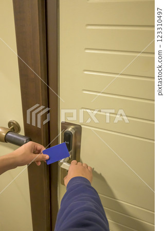 A hand inserting a blue card key into a modern hotel door lock, key electronic lock, hotel room, holidays in mallorca, spain 123310497