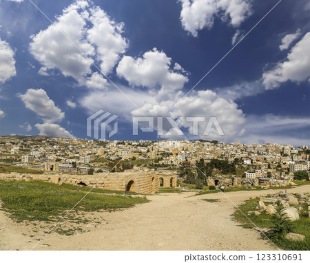 Roman ruins (against the background of a beautiful sky with clouds) in the Jordanian city of Jerash (Gerasa of Antiquity), capital and largest city of Jerash Governorate, Jordan Roman ruins (against the background of a beautiful sky with clouds) in the Jordanian city of Jerash (Gerasa of Antiquity), capital and largest city of Jerash Governorate, Jordan 123310691