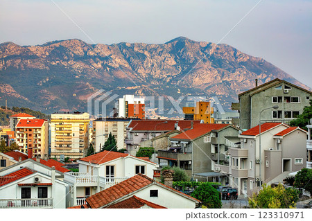 A mountain backdrop overlooking the bustling hillside district of Budva at dusk. A mountain backdrop overlooking the bustling hillside district of Budva at dusk. 123310971