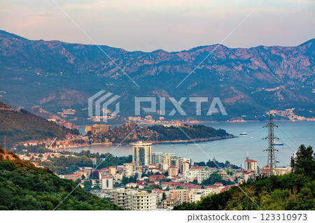 A picturesque view of the coastal town of Budva nestled between mountains at dusk. A picturesque view of the coastal town of Budva nestled between mountains at dusk. 123310973
