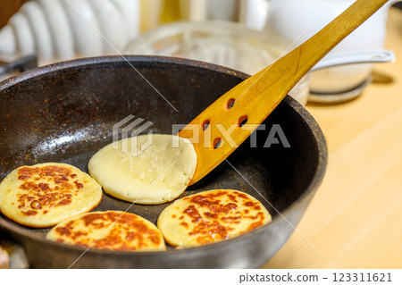Delicious and Fluffy Pancakes Cooking in a Skillet on the Stovetop with Buttery Goodness 123311621