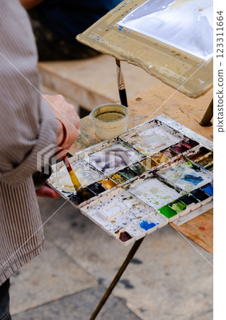 Street artist at work with watercolor 123311664