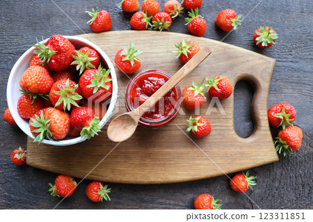 Homemade strawberry jam or marmalade in the glass jar and the fresh strawberries on the wooden rustic table . 123311851