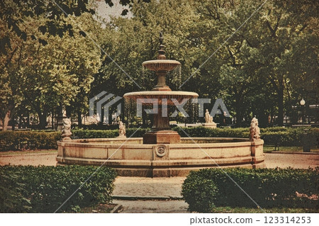 Vintage fountain in a peaceful park setting surrounded by lush greenery 123314253