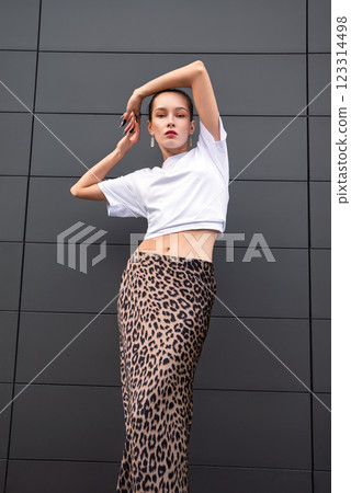 Confident Woman in Urban Fashion . Bold Leopard Print Skirt and White Crop Top 123314498