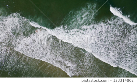 Overhead view of waves crashing on sandy beach 123314802