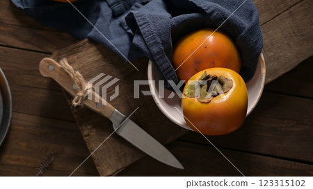 Ripe persimmons on a rustic wooden table 123315102