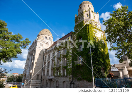 Budapest, Hungary, August 29, 2022. The imposing and elegant facade of the Gellert Hotel and Thermal Baths. One of the most luxurious in the city. A yellow taxi with tourists at the entrance. Budapest, Hungary, August 29, 2022. The imposing and elegant facade of the Gellert Hotel and Thermal Baths. One of the most luxurious in the city. A yellow taxi with tourists at the entrance. 123315109
