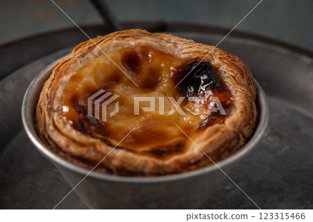 Golden-brown Portuguese custard tart with a flaky crust Golden-brown Portuguese custard tart with a flaky crust 123315466