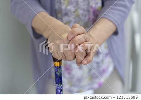 Hands of a woman in her 80s holding a cane 123315699