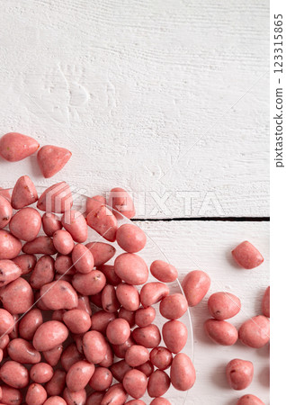 Dried fruits and berries in chocolate glaze. Pink candies on a white wooden background. 123315865