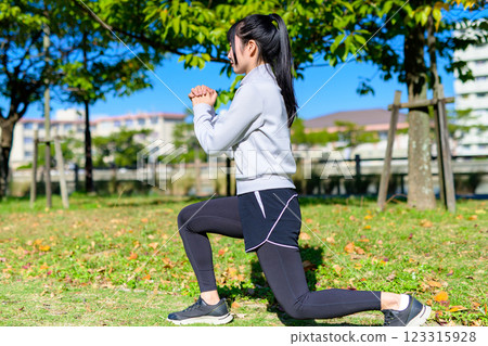 Young woman training her lower body in a green space: lunges, squats, self-improvement, diet Young woman training her lower body in a green space: lunges, squats, self-improvement, diet 123315928