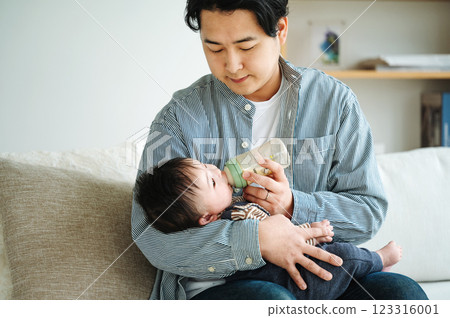Daddy giving milk to baby 123316001
