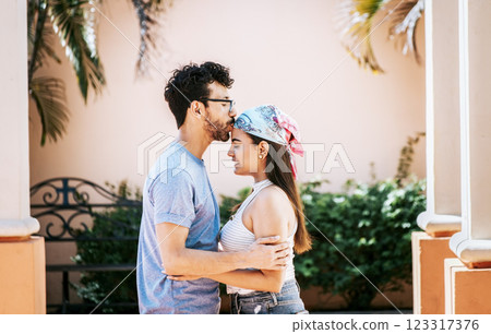 Man kissing his girlfriend forehead outside. Cute couple embracing the boyfriend kisses the girl forehead. Portrait of beautiful couple in love. Boyfriend tenderly kissing his girlfriend forehead 123317376