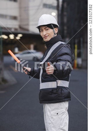 A young man directing traffic 123317382